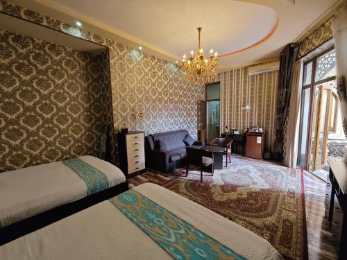 une chambre avec deux lits, un bureau et une chaise dans l'établissement Mosaic Boutique Hotel, à Samarcande