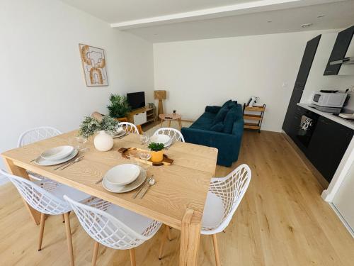 a dining table and chairs in a living room at Charmant Appartement Rénové l 2 chambres in Réalmont