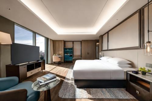 a bedroom with a large bed and a living room at Crowne Plaza Hangzhou Linping by IHG in Hangzhou