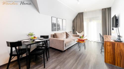 ソスノフカにあるWonder Hill - klimatyzowane apartamenty z bajkowym widokiem na góry i zalewのソファとテーブルのあるリビングルーム