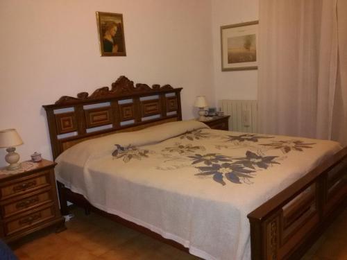 1 dormitorio con 1 cama grande con marco de madera en Casa vacanze Tuoro, en Tuoro sul Trasimeno