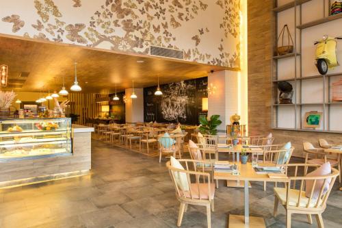 a restaurant with tables and chairs and a bakery at Fusion Suites Saigon in Ho Chi Minh City