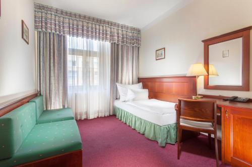 Pokój hotelowy z łóżkiem, biurkiem i krzesłem w obiekcie Hotel Lunik w Pradze