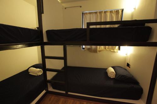 three bunk beds in a room with a mirror at Hotel N45 in Kulai