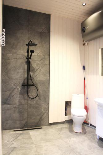a shower in a bathroom with a toilet at Metsamajake Hubert sauna ja mullivanniga looduse keskel in Sigula