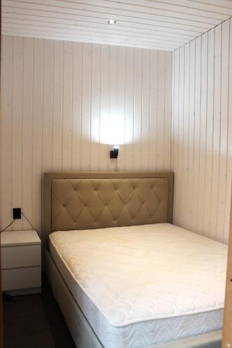 a bedroom with a bed with a light above it at Metsamajake Hubert sauna ja mullivanniga looduse keskel in Sigula