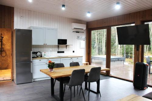 uma cozinha com mesa, cadeiras e geladeira em Metsamajake Hubert sauna ja mullivanniga 