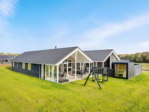 a house with a playground in the yard at 16 person holiday home in Sydals in Sarup