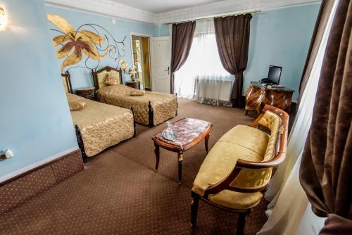 a hotel room with a bedroom with two beds and a table at Pensiunea Paradis in Râmnicu Vâlcea