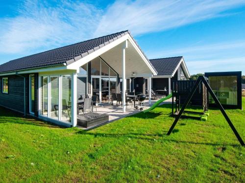 a house with a slide and a playground at 16 person holiday home in Sydals in Sarup
