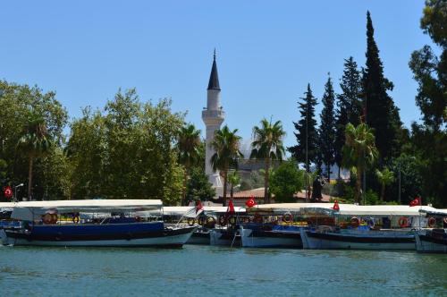 three boats in the water with a tower in the background at Central Park Otel - Adult Only in Dalyan