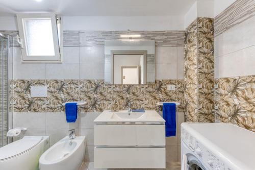 a bathroom with a sink and a tub and a toilet at Mauricarol Residences in Acquarica del Capo