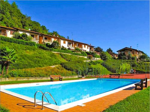 a large swimming pool with two benches next to a hill at Residenza La Rocca in Castello Valsolda
