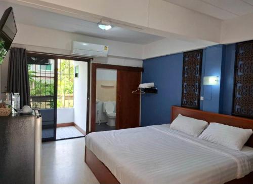 a bedroom with a large bed with a blue wall at Ratchawong Place ราชวงศ์ เพลส --หลังพ่อขุน-- in Phayao