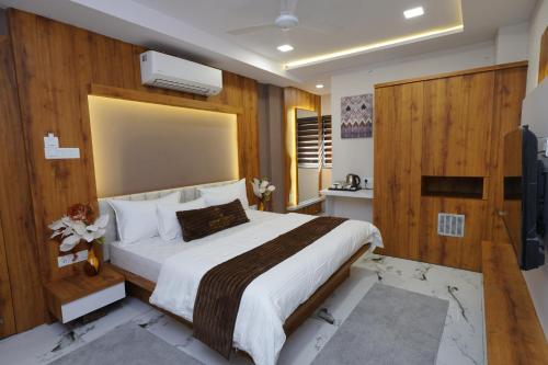 Un dormitorio con una cama grande y un televisor. en Hotel Deol's Paradise, en Indore
