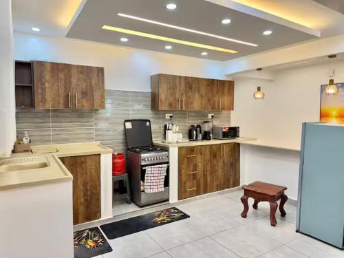 a large kitchen with wooden cabinets and a stove at Zuri Cosy Stay Nyali, Furnished 2 bedroom in Mombasa
