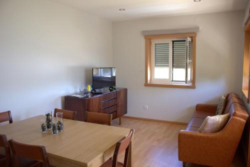 a dining room with a table and chairs and a television at Casa do Regueirinho in Vila Nova de Cerveira