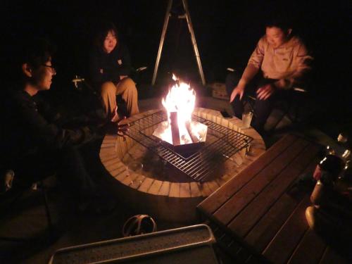 a group of people sitting around a fire pit at ホシヤドリ hoshiyadori in Setouchi