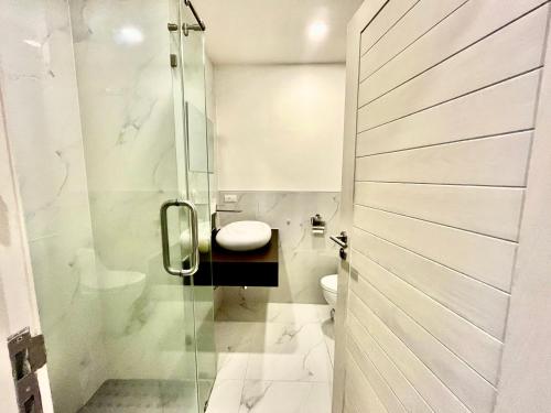 a bathroom with a toilet and a glass shower at Cozy Garden Apartment Butterfly Karon beach in Ban Karon
