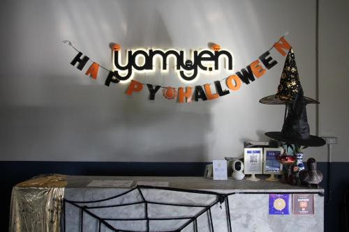 Una mesa con un cartel que dice «Vennan, feliz Halloween». en Yam Yen Hostel, en Lat Krabang