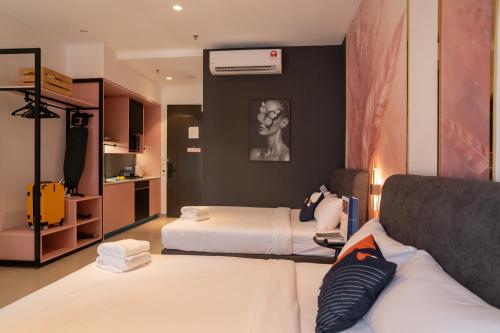 een hotelkamer met twee bedden en een bank bij Paxtonz Mana-Mana Suites Kuala Lumpur in Petaling Jaya