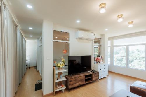 a living room with a tv and a large mirror at บ้านเลม่อนริเวอร์ไซด์ in Nan