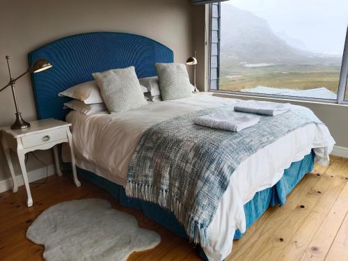 Un dormitorio con una cama grande con una ventana grande. en Tranquility Heights, en Pringle Bay
