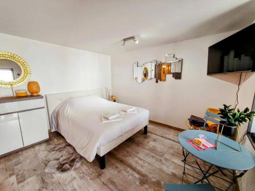 une chambre avec un lit, une table et un miroir dans l'établissement Le République, Rez de Chaussée, Extérieur, 2 pers, à Auxerre