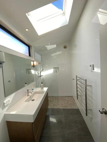 une salle de bain avec un lavabo et un grand miroir dans l'établissement Reliance Classic Escape, à Omaha