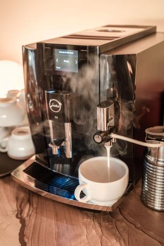 eine Kaffeemaschine mit einer Tasse auf dem Tisch in der Unterkunft Ohorongo Safari Lodge in Kamanjab