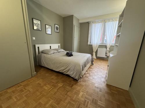 une chambre avec un lit et deux fenêtres dans l'établissement Rétro Lomme, à Lille