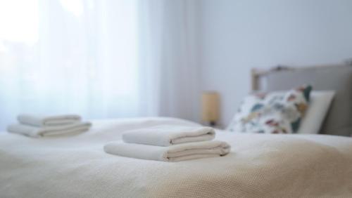 drei Handtücher auf einem weißen Bett gestapelt in der Unterkunft Lovely&quiet, free parking, 24h self check in in Zagreb