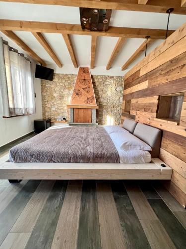 a bedroom with a large bed with a wooden wall at Agriturismo Tamellini in Soave