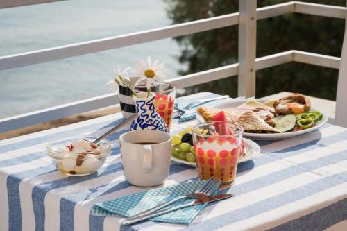 a table with a plate of food and a plate of food at Hermes Beach Front in Stalos