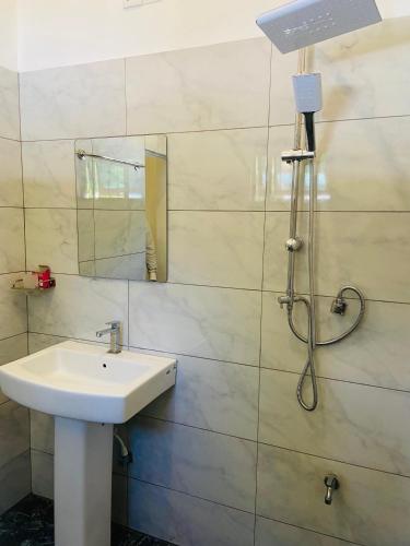 a bathroom with a sink and a mirror at Lodge in Resolute in Dambulla