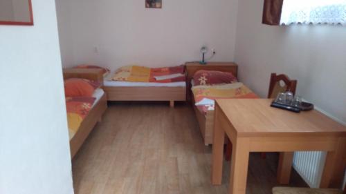 a small room with two beds and a table at Penzión Pars in Žilina