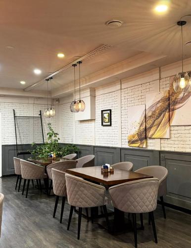 un restaurant avec des tables et des chaises dans une salle dans l'établissement SK Hotel, à Bishkek