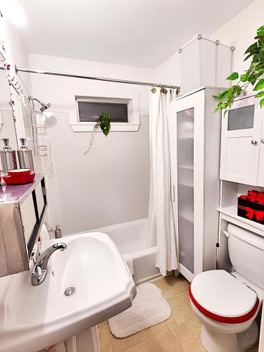 a white bathroom with a toilet and a sink at Central Queen Anne Home, Walking Score 96 in Seattle