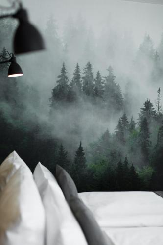 a bedroom with a view of a pine forest at Hotel Nickisch in Schüttorf