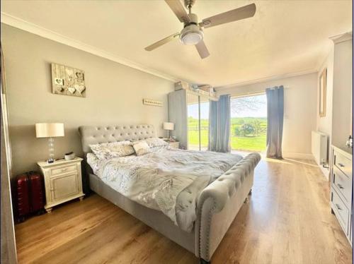 FotherbyにあるThe Old Charming Houseの天井ファン付きの大きなベッドのある寝室