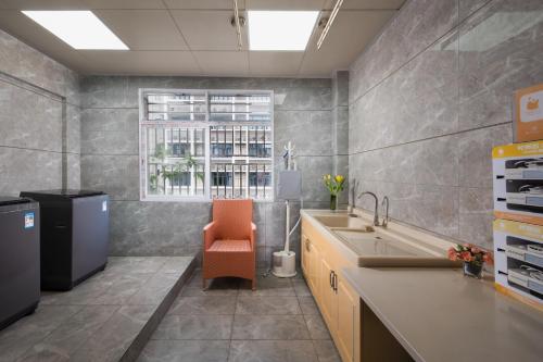 深セン市にあるMotri莫里宝乐城市酒店のキッチン(シンク、オレンジの椅子付)