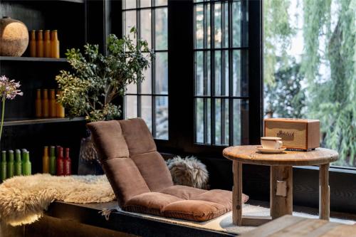 a living room with a brown chair and a table at Silent NOISELESS Homestay in Lijiang