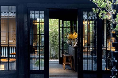 an entrance to a store with glass doors and a stool at Lijiang Old Town Noiseless Zen Courtyard in Lijiang