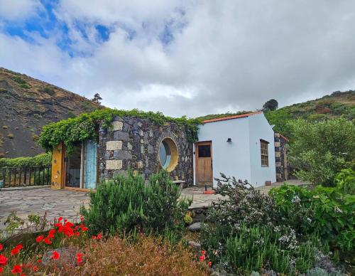 a small white house with a yard with flowers at Casa La Tedera in El Pinar del Hierro