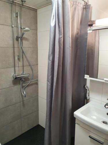 a bathroom with a shower curtain and a sink at Luxury 1br apartment in Liminka
