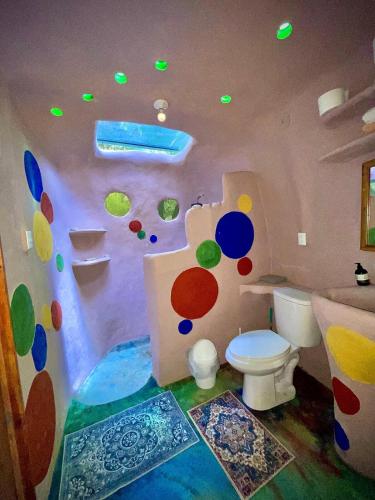 ein Badezimmer mit Toilette und einer gestrichenen Wand in der Unterkunft Dome 2 in Rivas