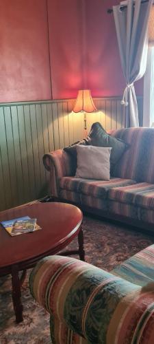 a living room with a couch and a table at May Queen Forest Cottage Manjimup in Deeside