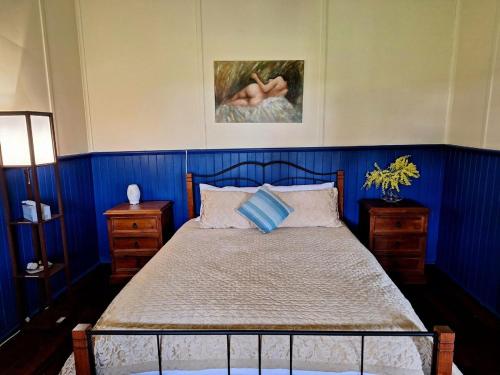 a bedroom with a bed with blue walls at The May Queen - Footsteps in the Forest in Balbarrup