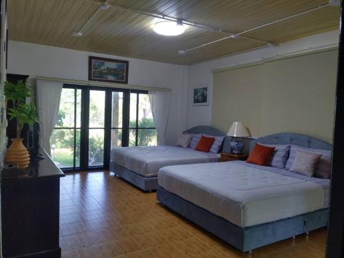 a living room with two beds and a couch at พฤกษาวารี รีสอร์ท 