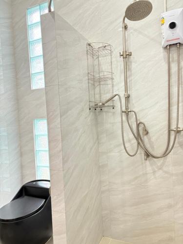 a shower with a black toilet in a bathroom at พฤกษาวารี รีสอร์ท 